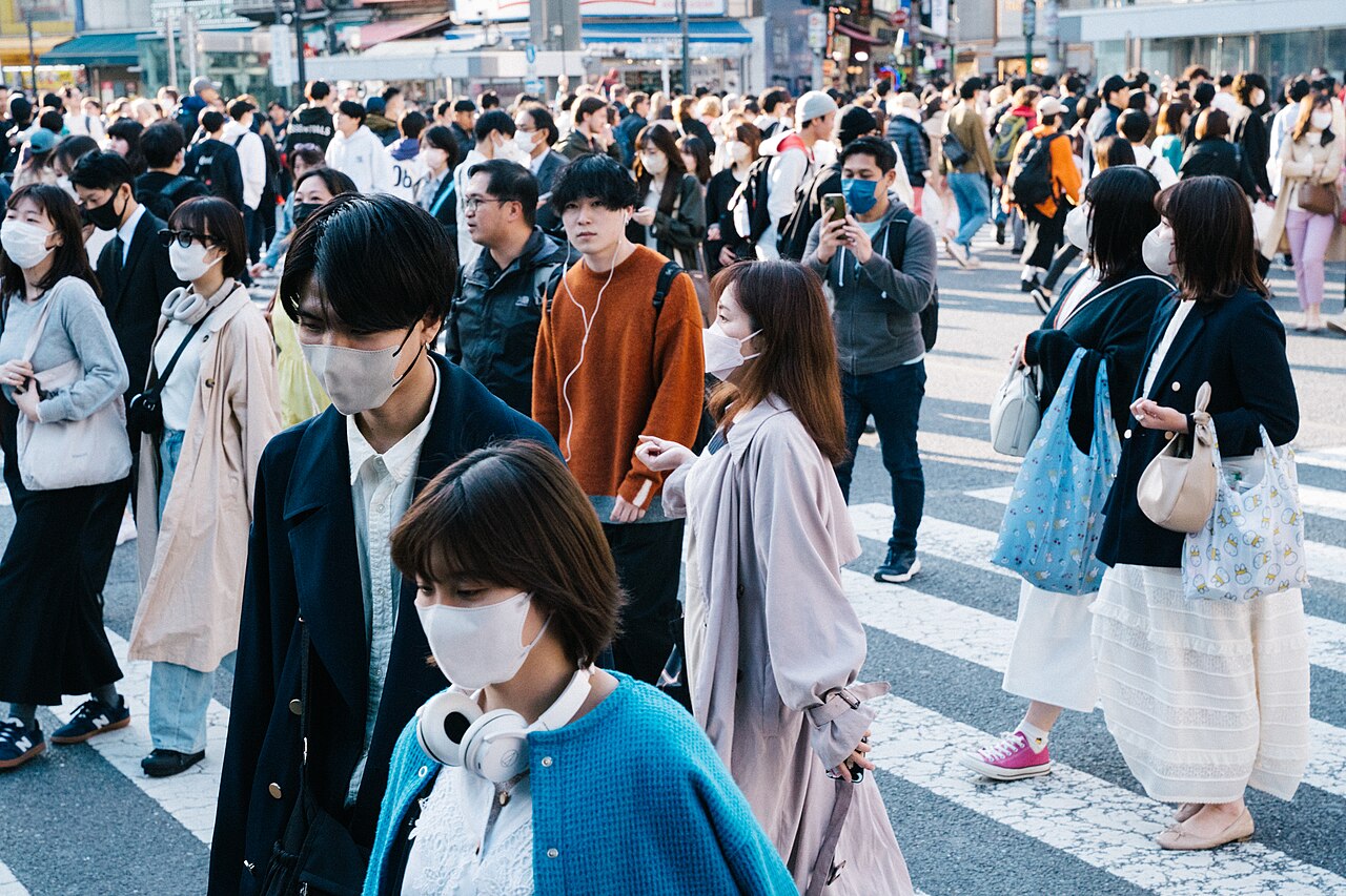 마스크를 쓴 사람들이 빽빽하게 무리 지어 도심의 횡단보도를 건너는 모습